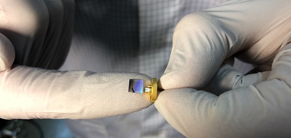 В руках ученого чип с интегральными микрорезонаторами из нитрида кремния (слева) и чип лазерного диода из фосфида индия в корпусе (справа). Фото авторов исследования